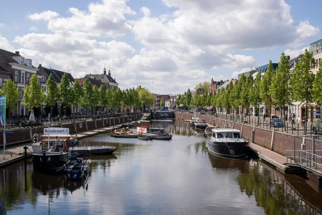 Charming view of boats along the canal in Breda, Netherlands, surrounded by historic architecture.